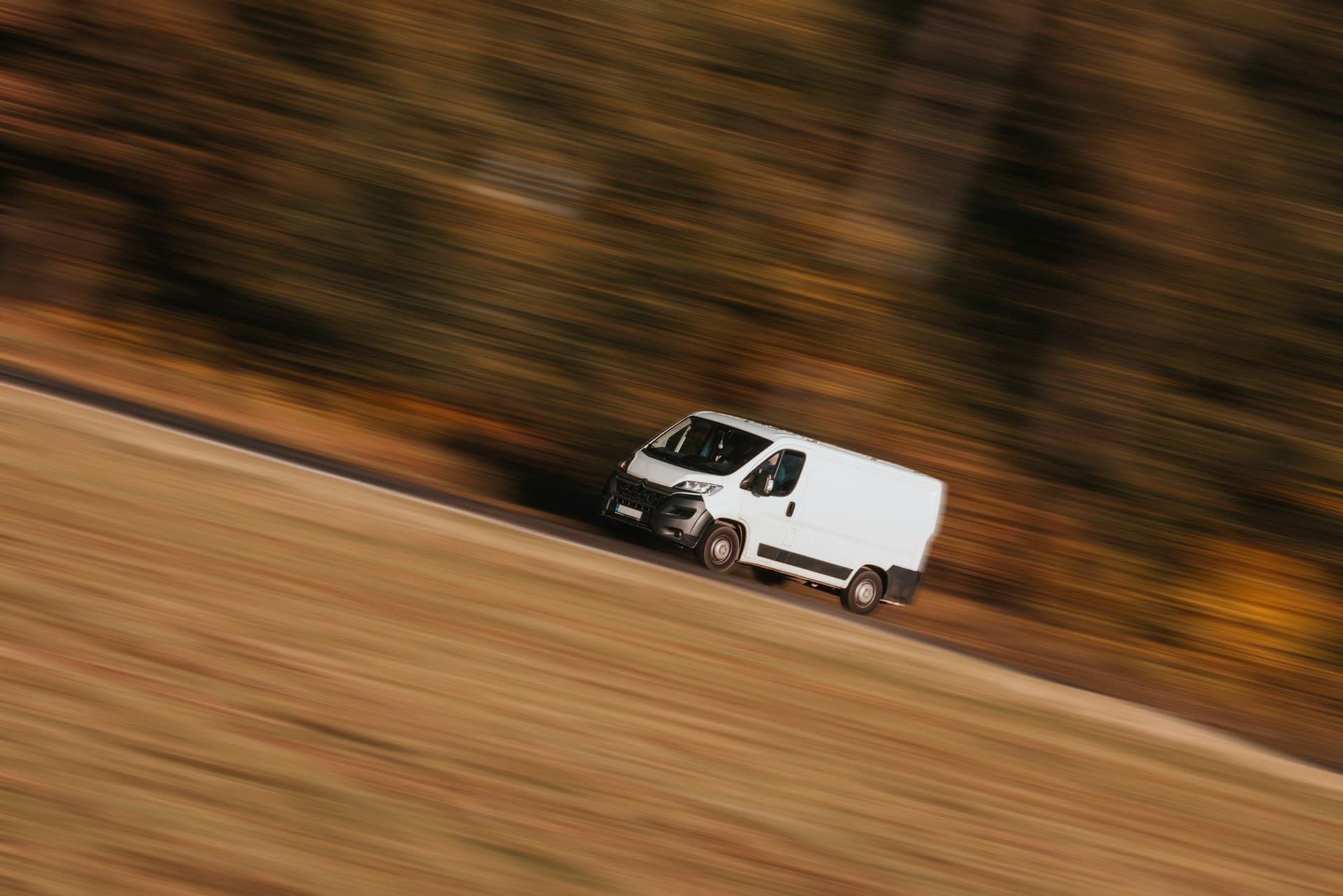 Beli kombi u vožnji na putu